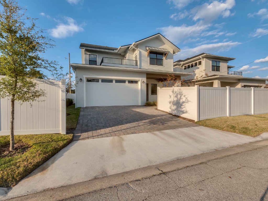Modern farmhouse new construction with white board-and-batten exterior, metal roof, and front porch in Orlando