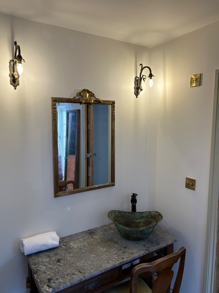 Hotel room - antique brass wall lights flanking vanity mirror