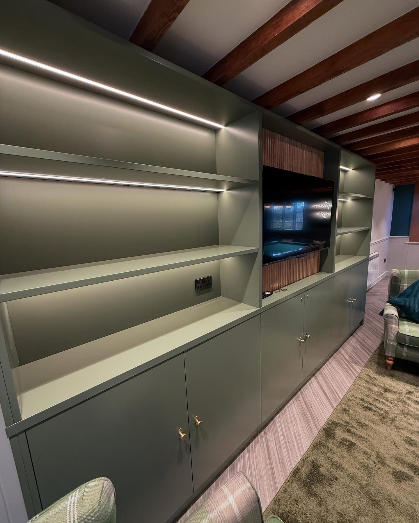 Media wall with vertical timber slats and integrated LED shelving