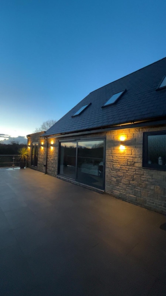Rear elevation - external wall lighting at dusk
