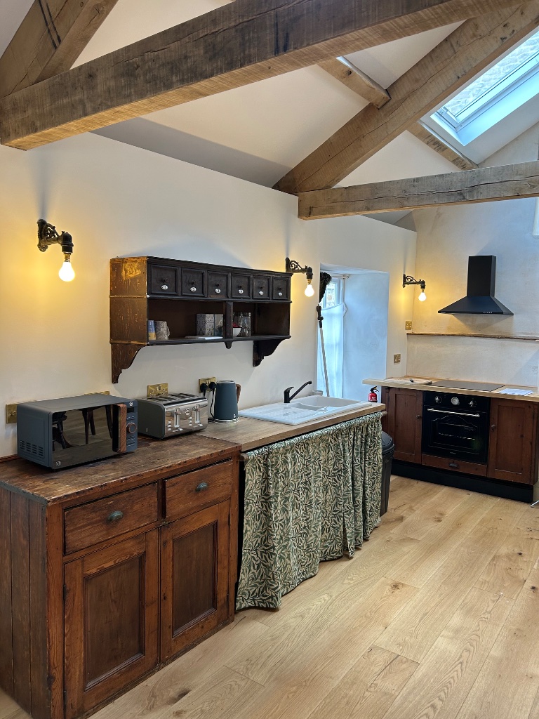 Hotel suite kitchen - antique wall lights with exposed beam ceiling
