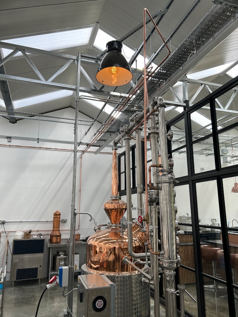 Copper still with pendant lamp - distillery floor