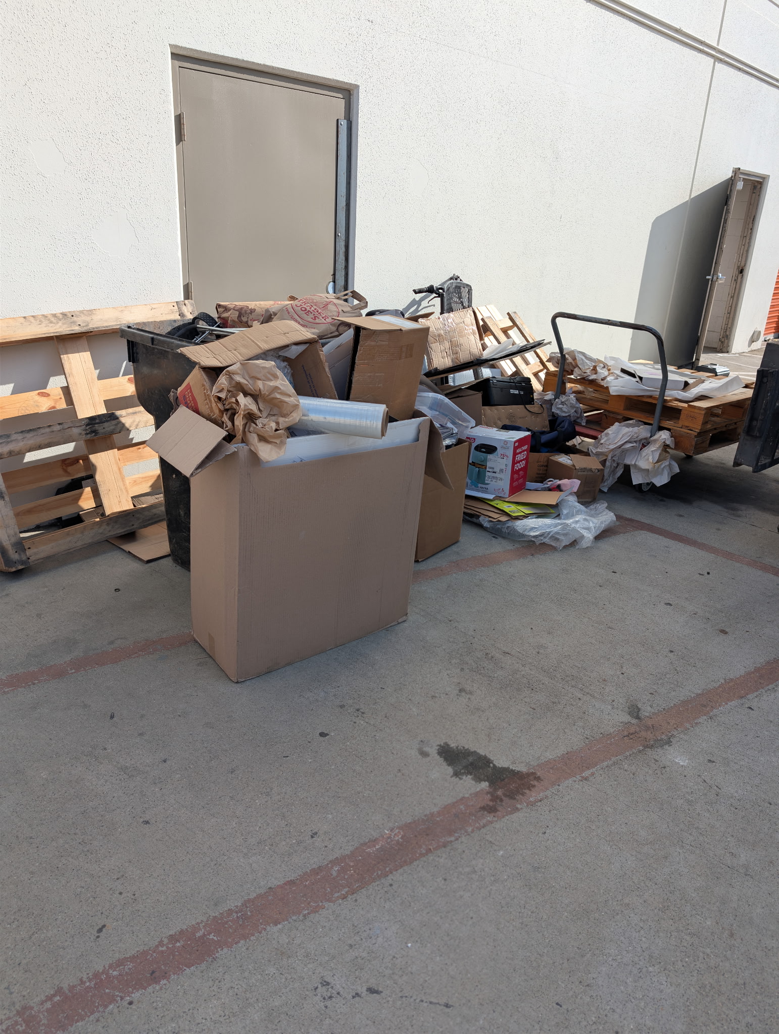 Warehouse loading dock clutter with cardboard boxes, pallets, and packing materials ready for junk removal