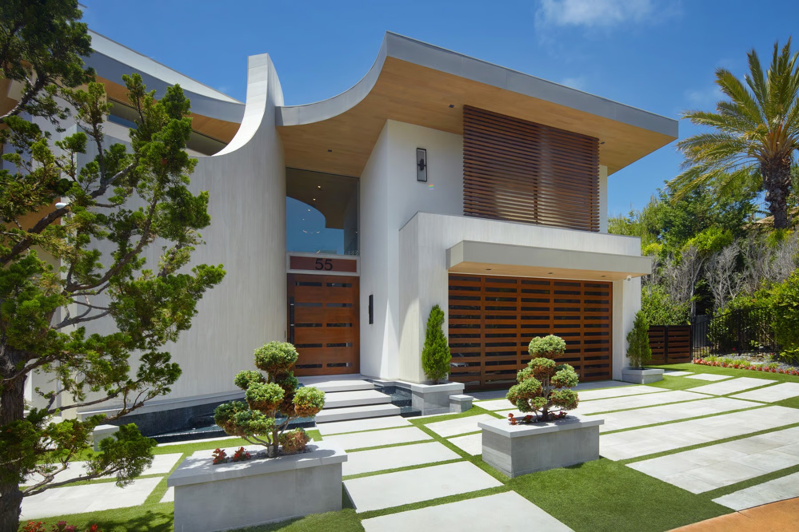 Ocean View modern luxury residence exterior with curved roofline and wood slats