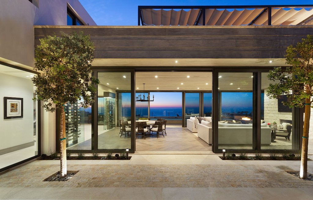 Pacific Ridge exterior at dusk with open glass walls and ocean view