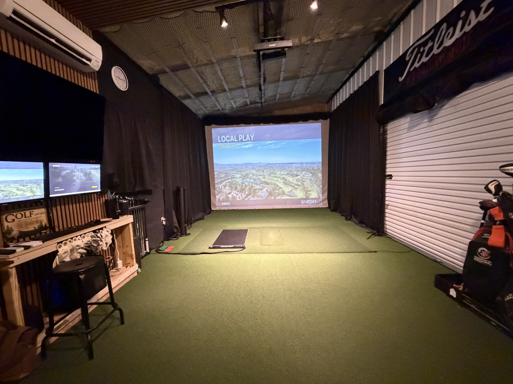 Head-on view of the golf simulator screen and hitting bay