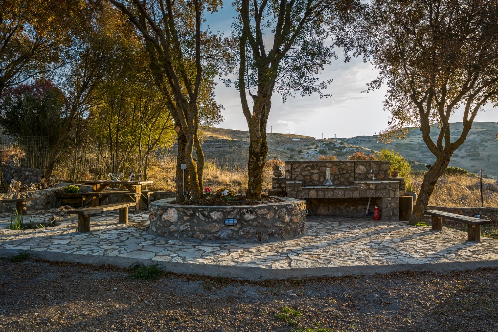 Outdoor stone terrace at Chalets Renata with autumn trees and mountain view
