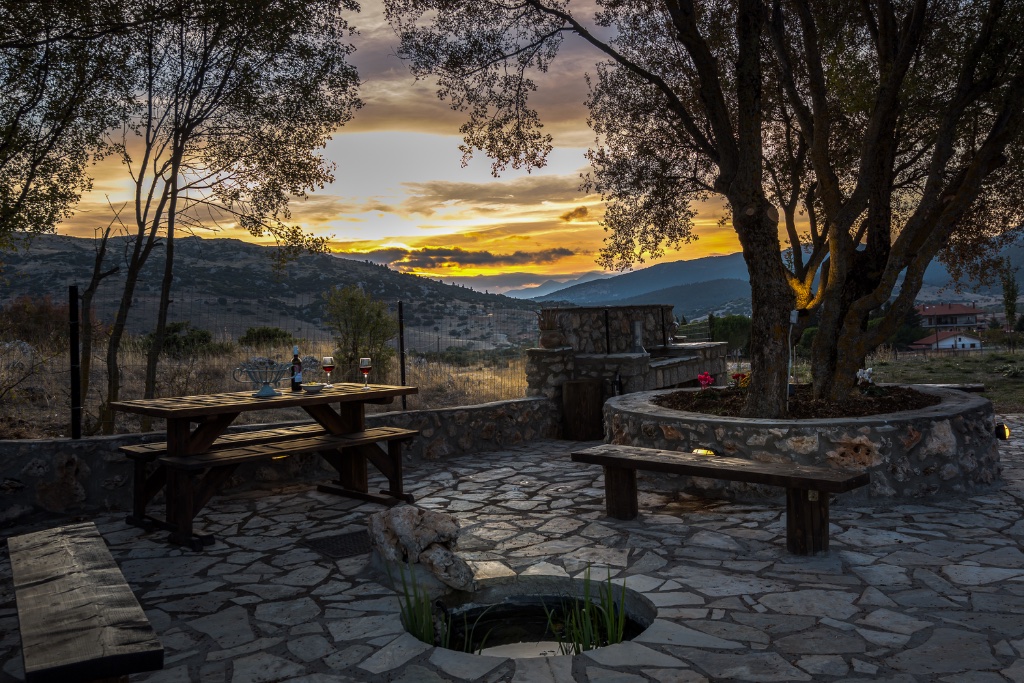 Outdoor stone terrace at sunset with Parnassos valley backdrop