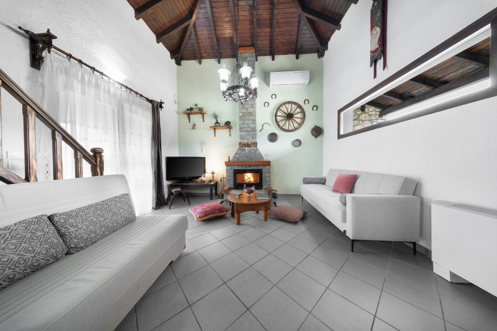 Living room with vaulted wooden ceiling and fireplace at Chalet Renata 1
