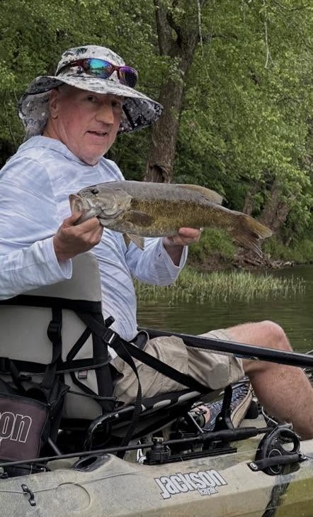 Angler in a kayak holding a smallmouth bass on a West Virginia river