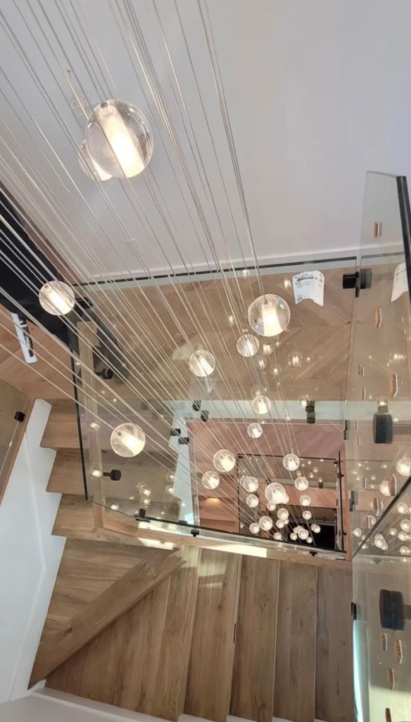 Glass ball chandelier over modern staircase