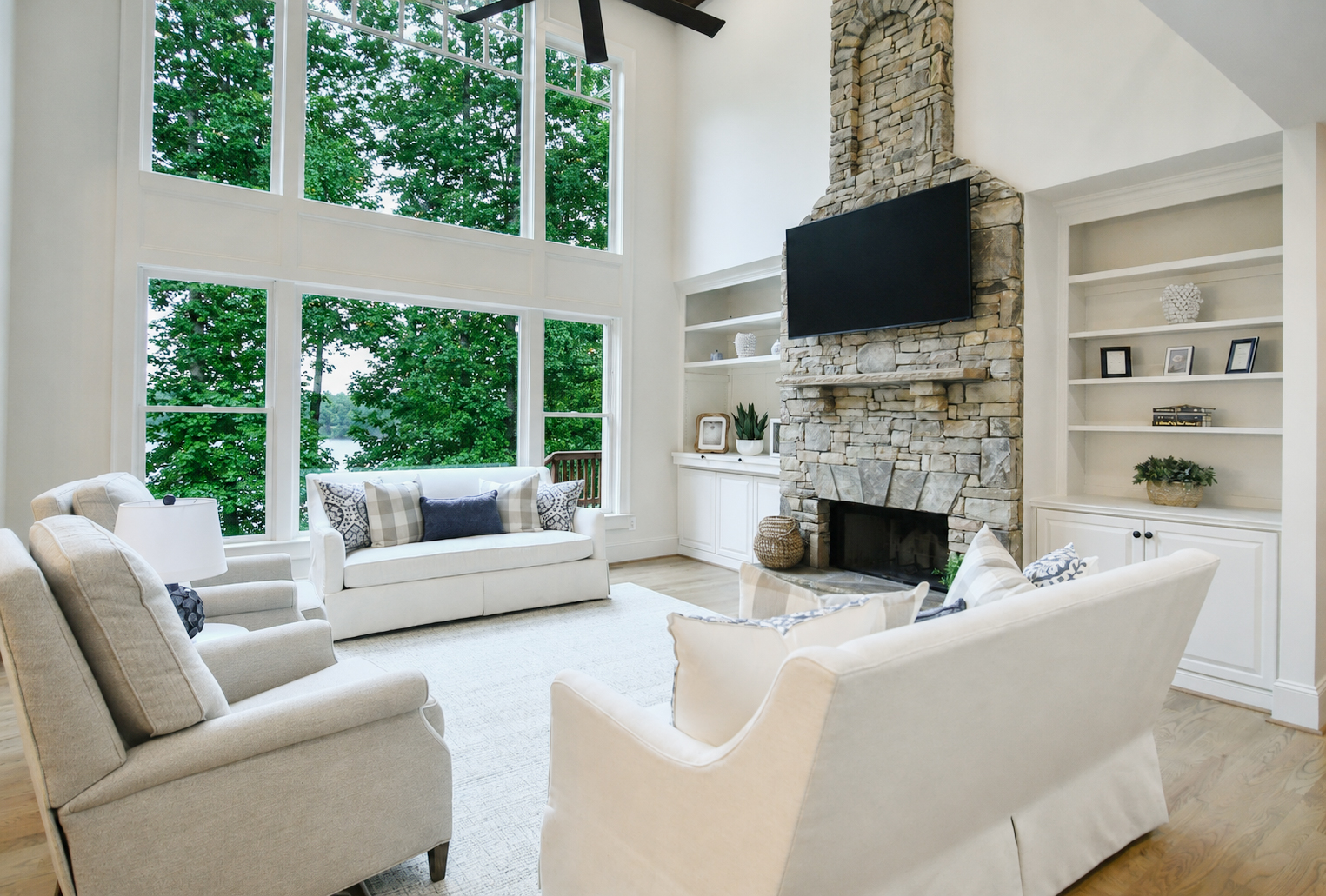 Photo 10 of 26 from Kade Homes' Lake Lanier, GA addition and renovation — vaulted great room with floor-to-ceiling stone fireplace and lake-view windows