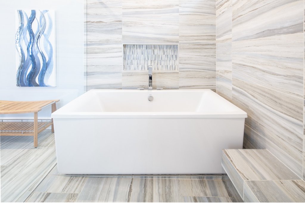 Primary bathroom renovation by Kade Homes & Renovations in Milton, GA, with floor-to-ceiling linear marble tile and a freestanding soaking tub