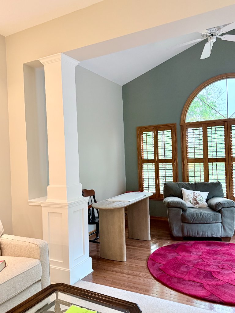 Living room with sage green accent wall and white columns
