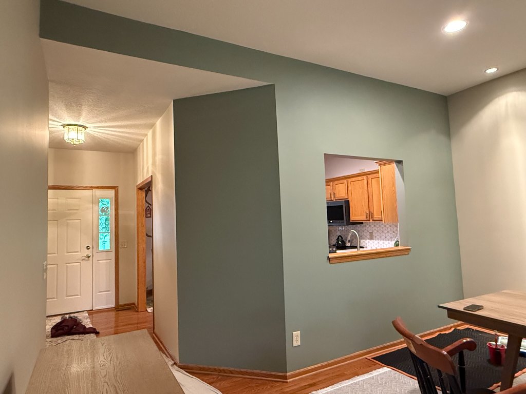 Dining area with sage green accent wall