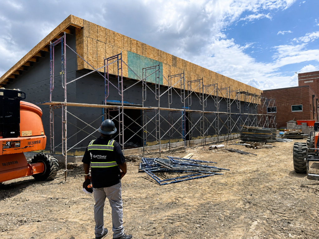 Construction professional reviewing architectural blueprints at a worksite