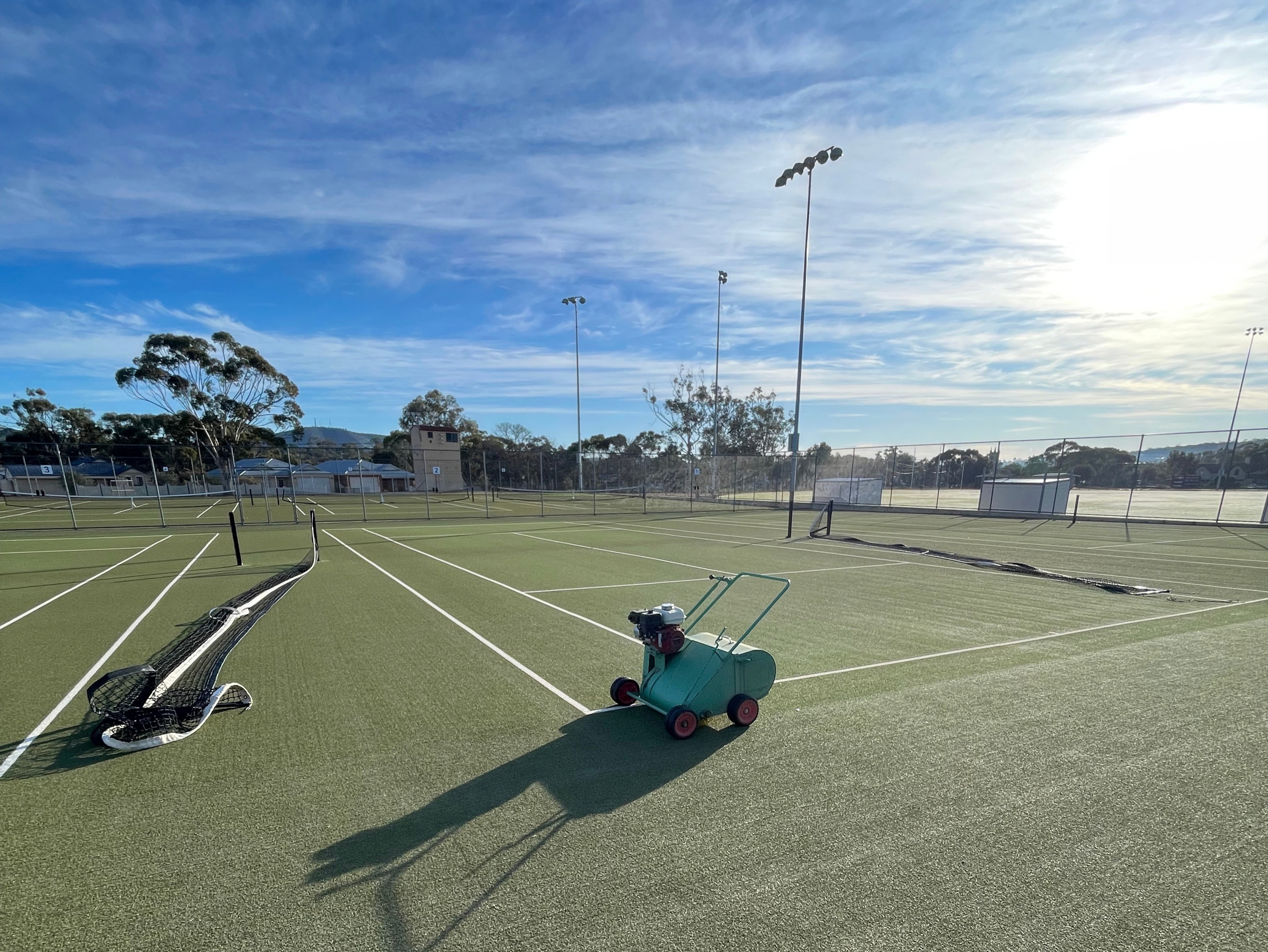 Walk-behind groomer restoring a synthetic court