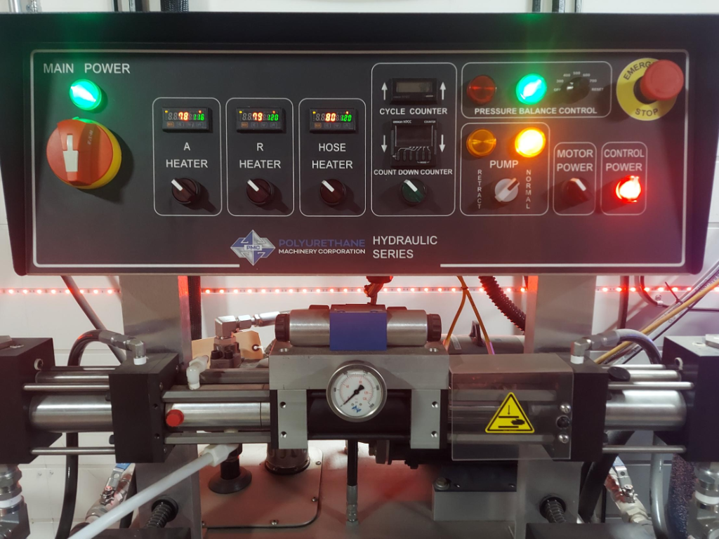 PMC spray foam proportioner temperature and pressure control panel showing A-side and B-side heater setpoints, hose temperature readouts, and pressure gauges used to maintain processing window