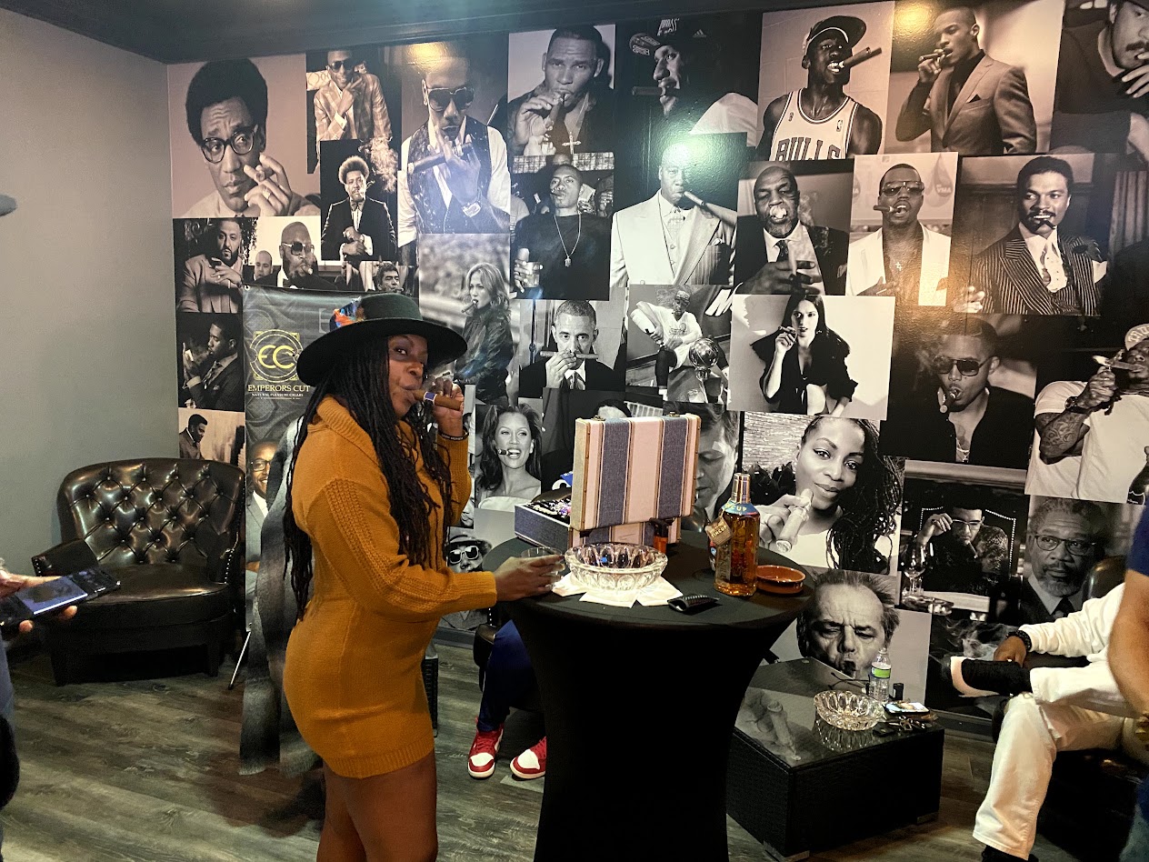 A woman enjoying a cigar in a lounge setting at 404 Smoke Shop