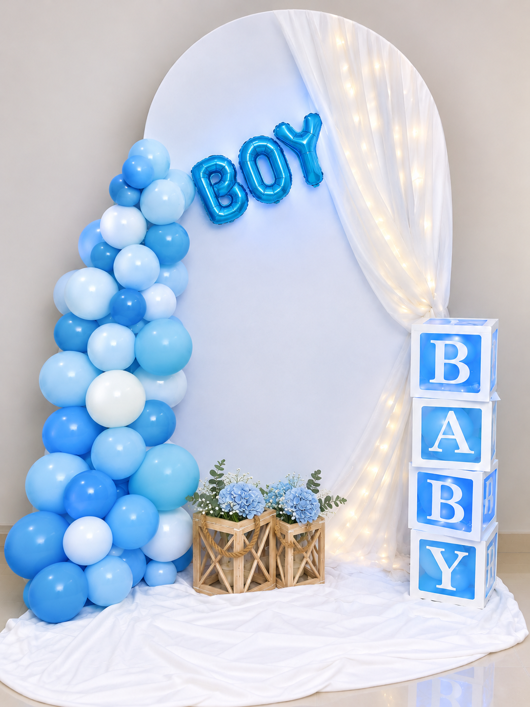 Baby boy celebration arch with blue and white balloon garland, BOY foil balloons and illuminated BABY letter blocks