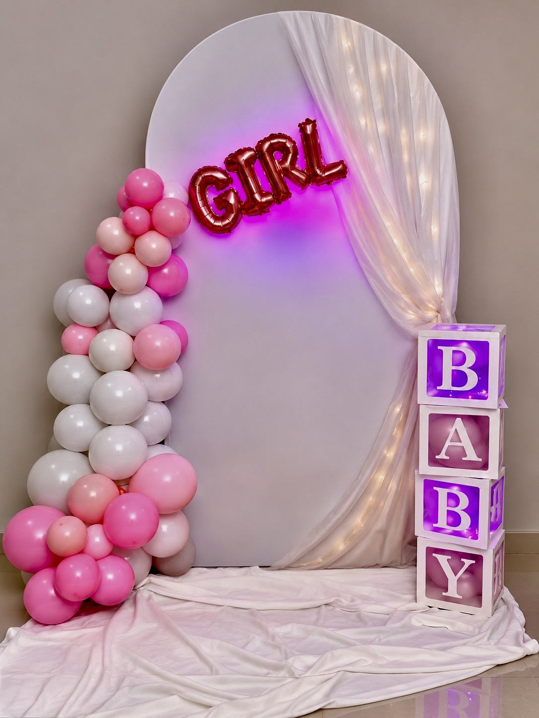 Baby girl celebration arch with pink balloon garland, GIRL foil balloons and illuminated BABY letter blocks