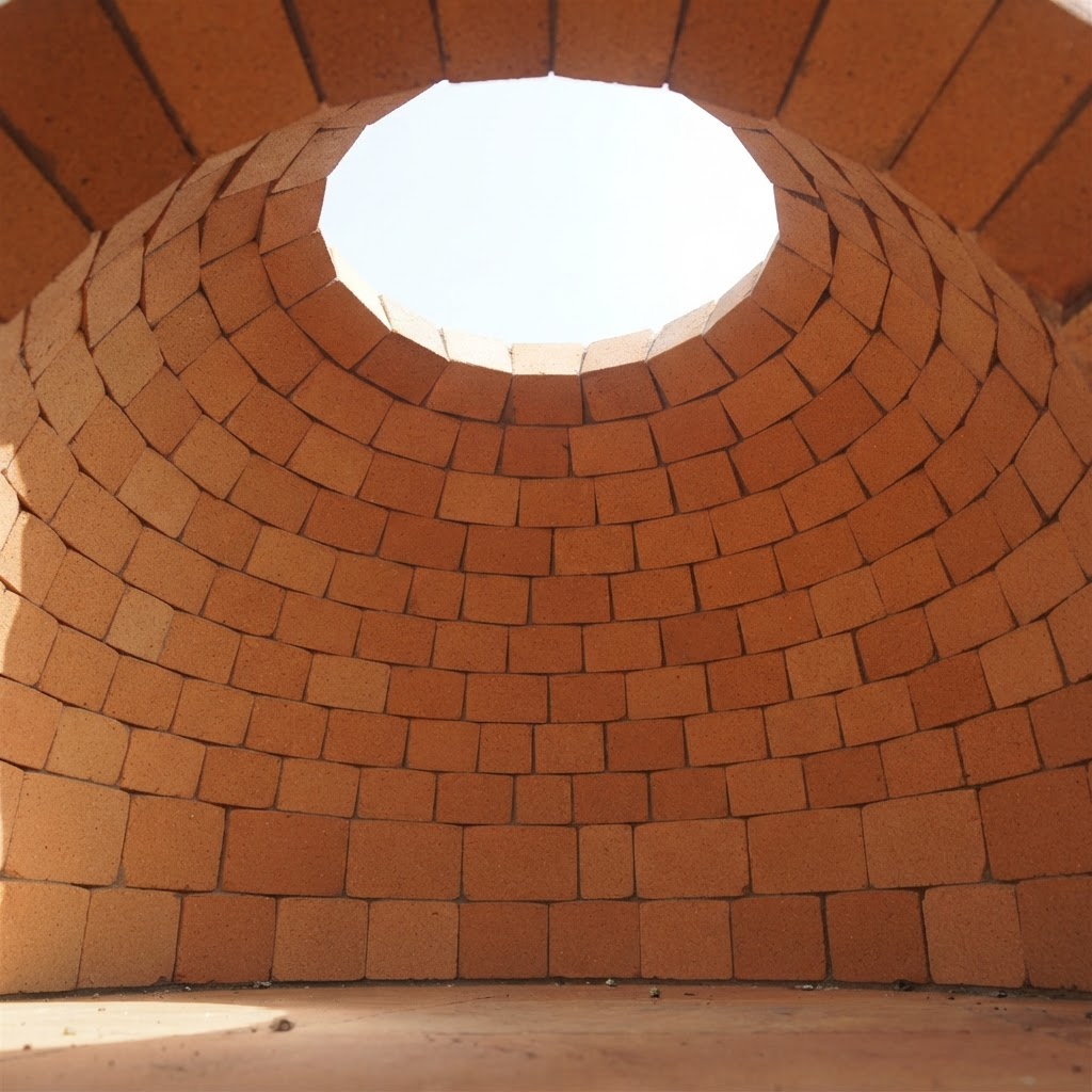The hand-laid firebrick interior of a masonry oven dome under construction
