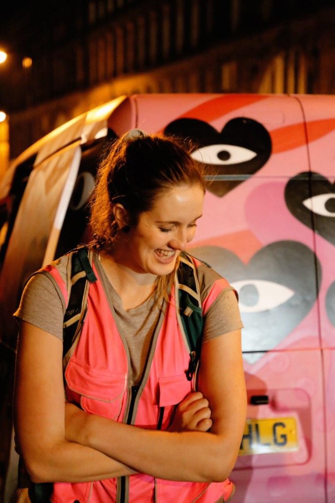 Volunteer in safety vest by vehicle