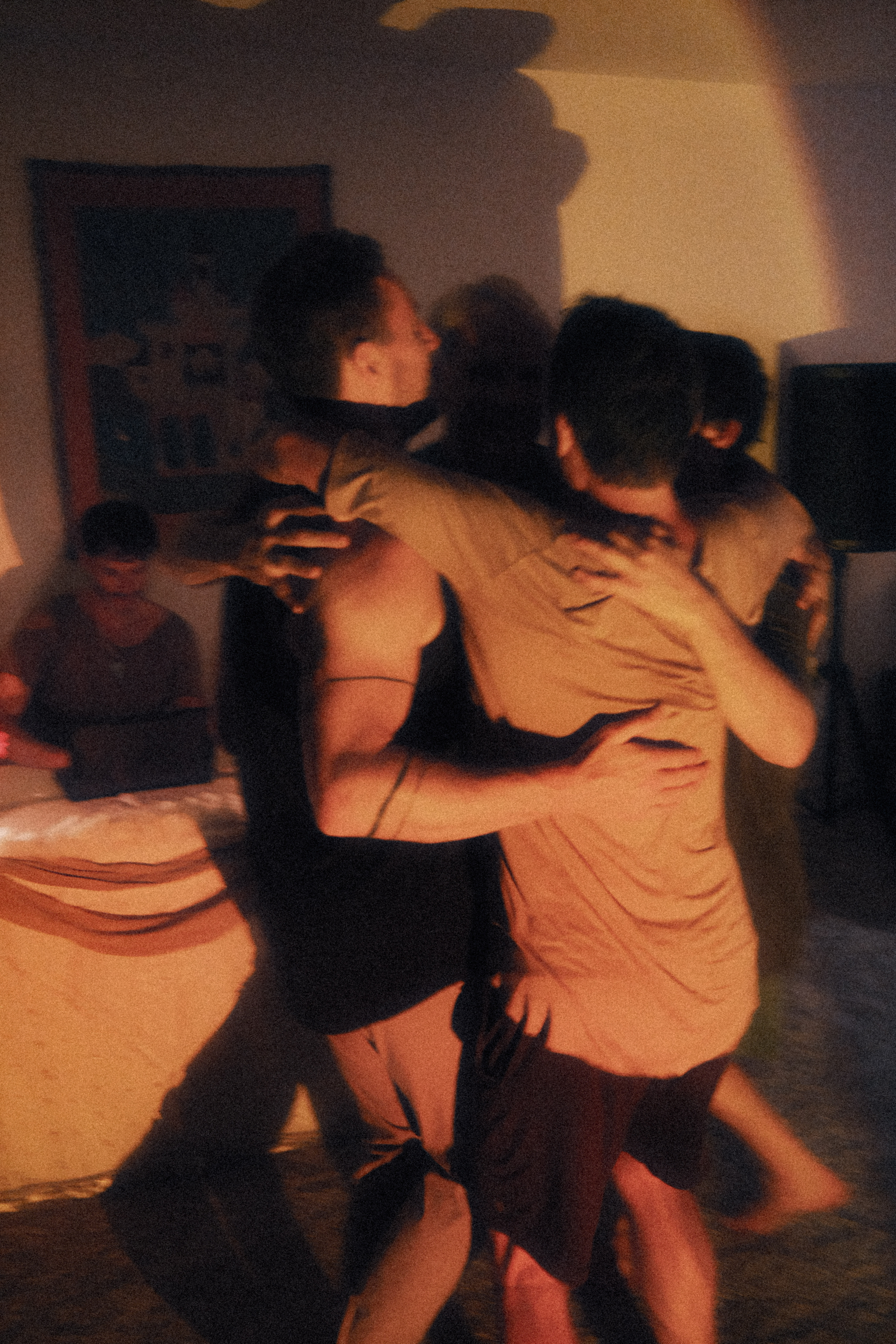 Two people hugging in a warm, dimly lit room
