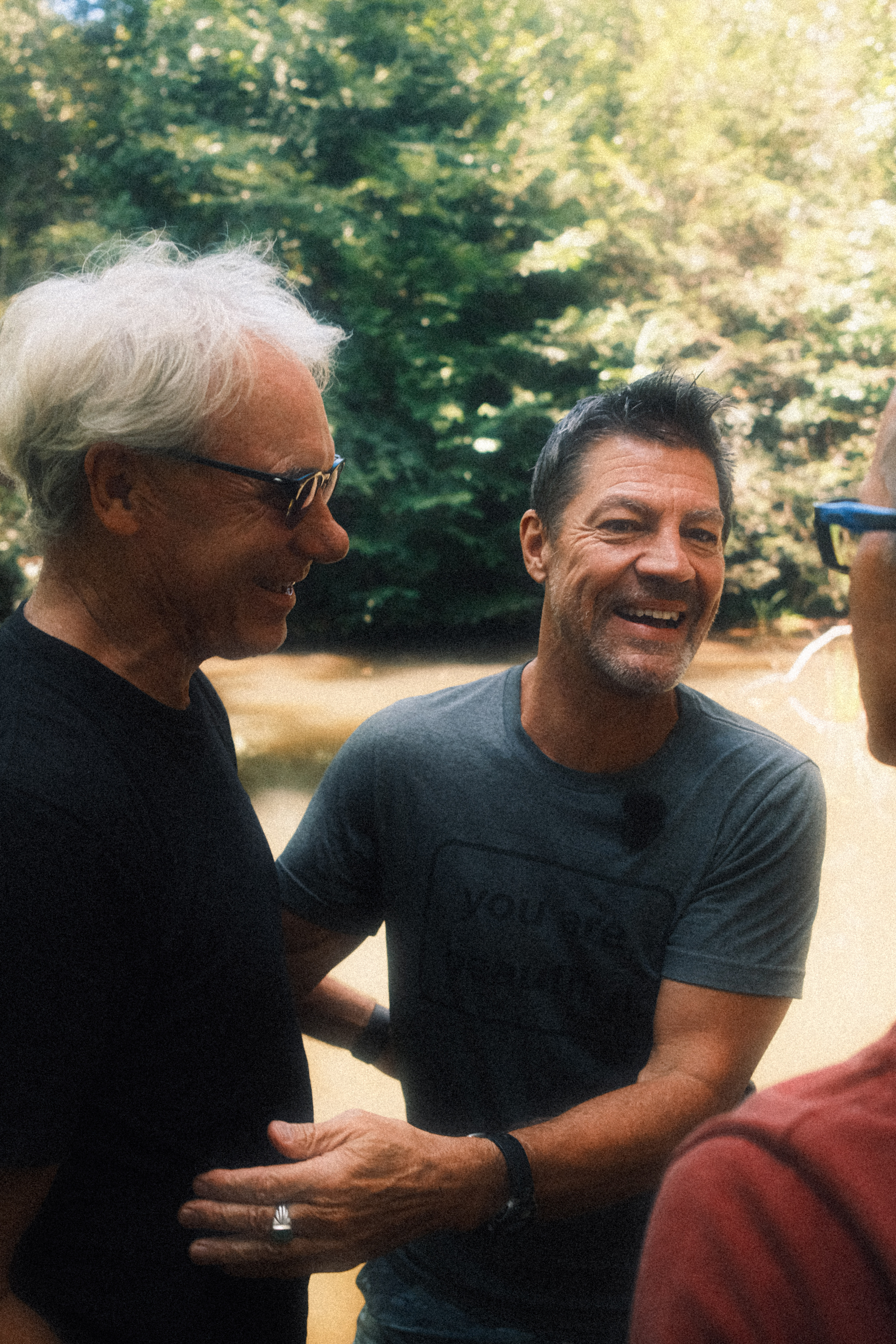 Three men in conversation by the water