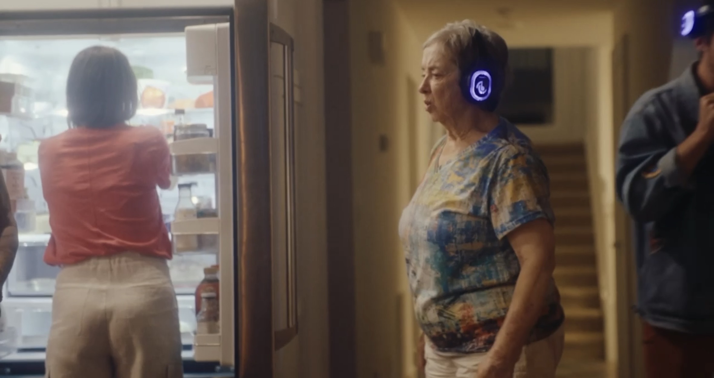 An indoor gathering by the refrigerator