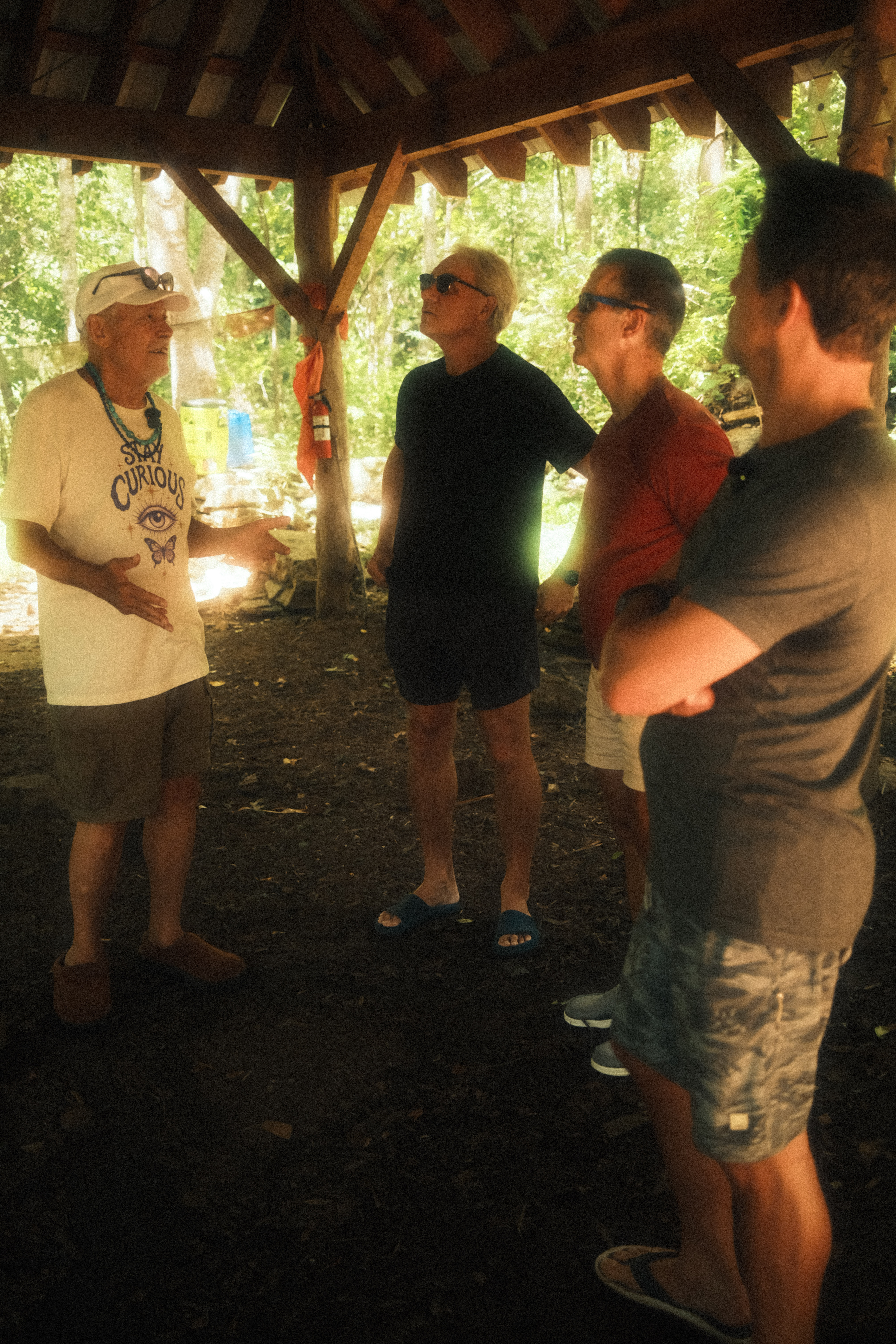Four men under the pavilion in the woods
