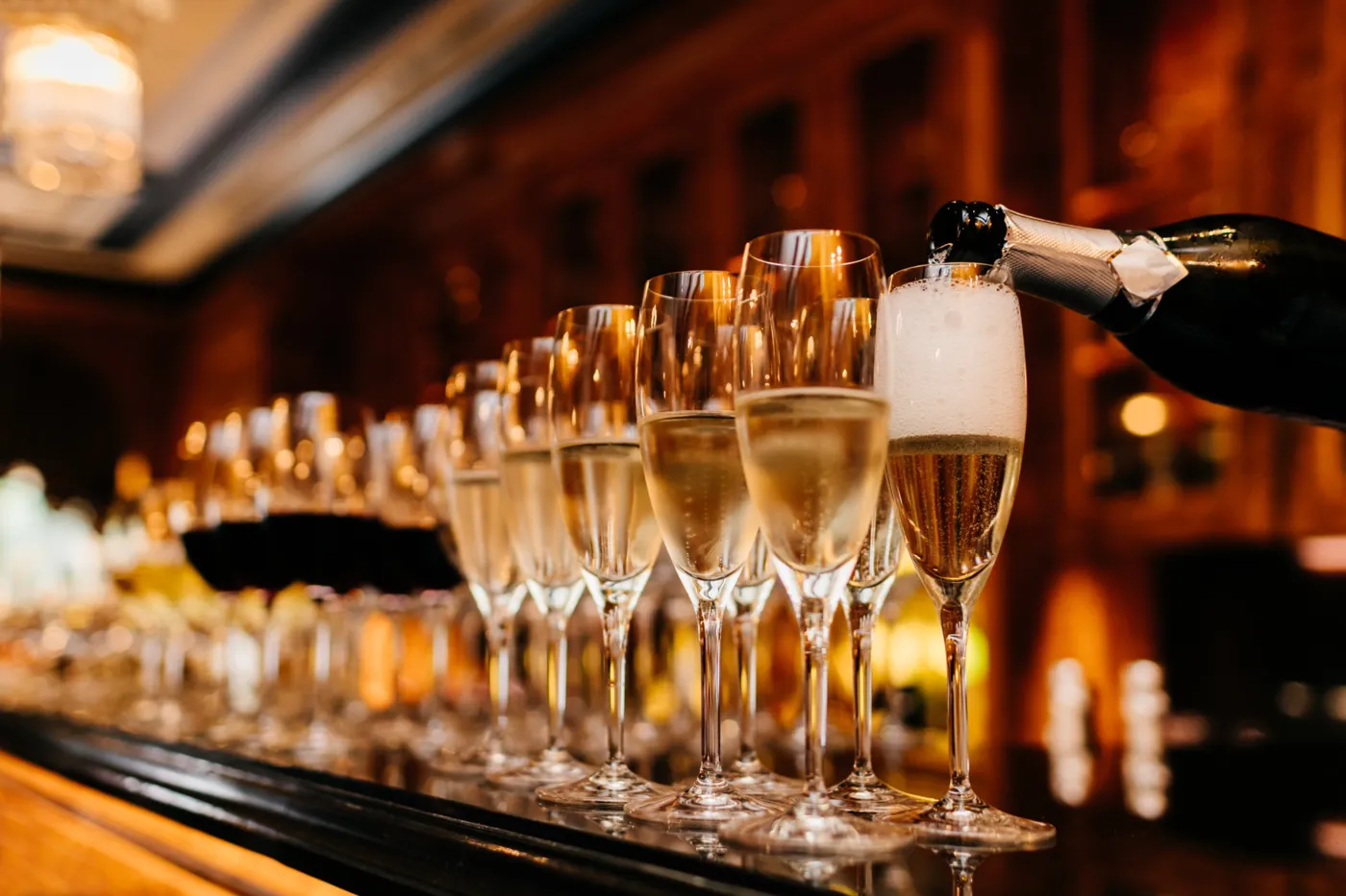 Sekt wird in eine Reihe Gläser eingeschenkt