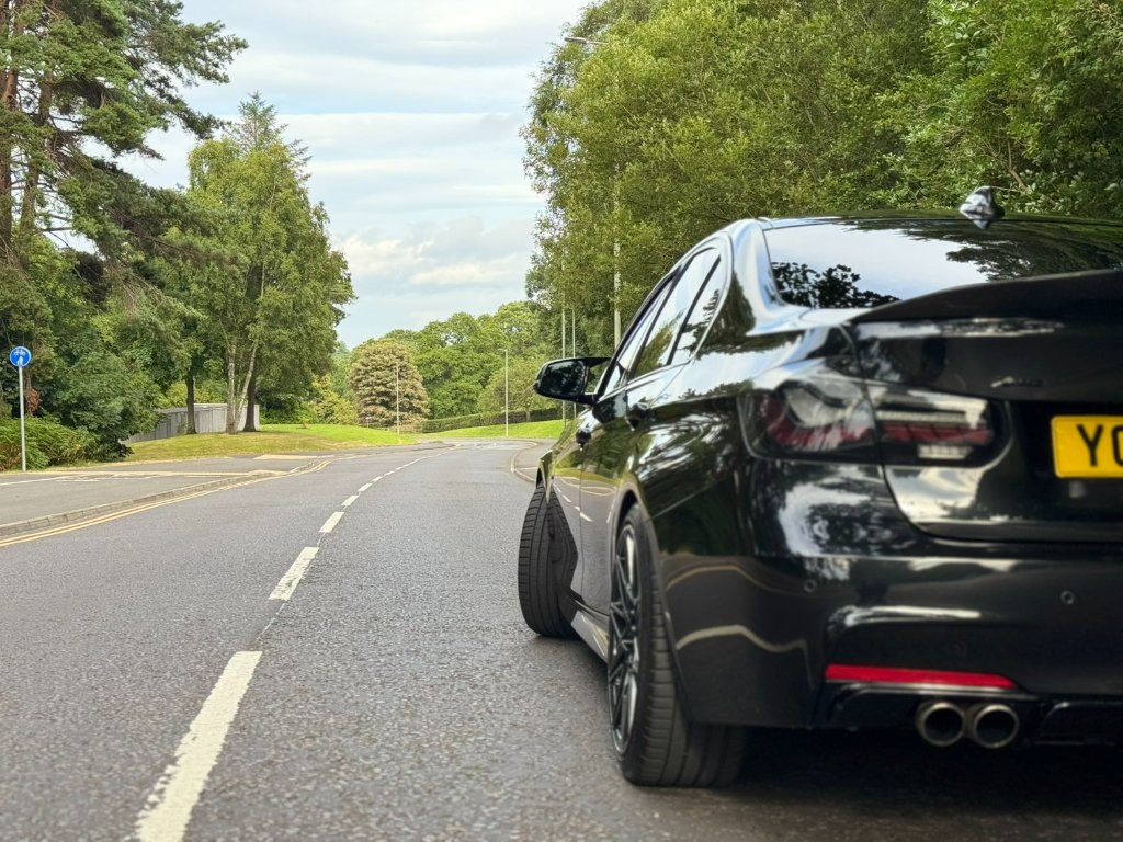 Black sedan — high-gloss rear three-quarter finish