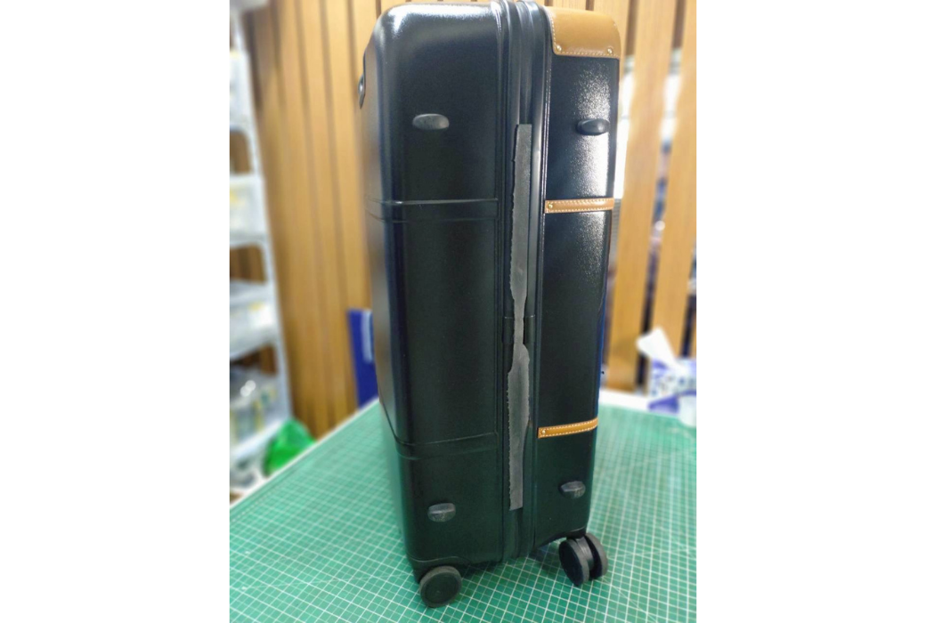 黒いハードケースの開閉部分、ヒンジの継ぎ目に沿って割れが入った状態