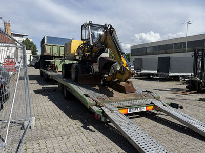 Mobilbagger wird für den Transport auf den Tieflader verladen