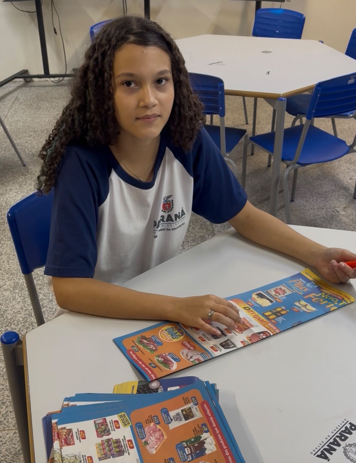 Aluna com encartes de supermercado (matéria-prima)
