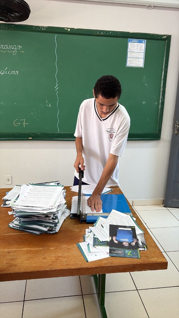 Arthur cortando o papel na medida