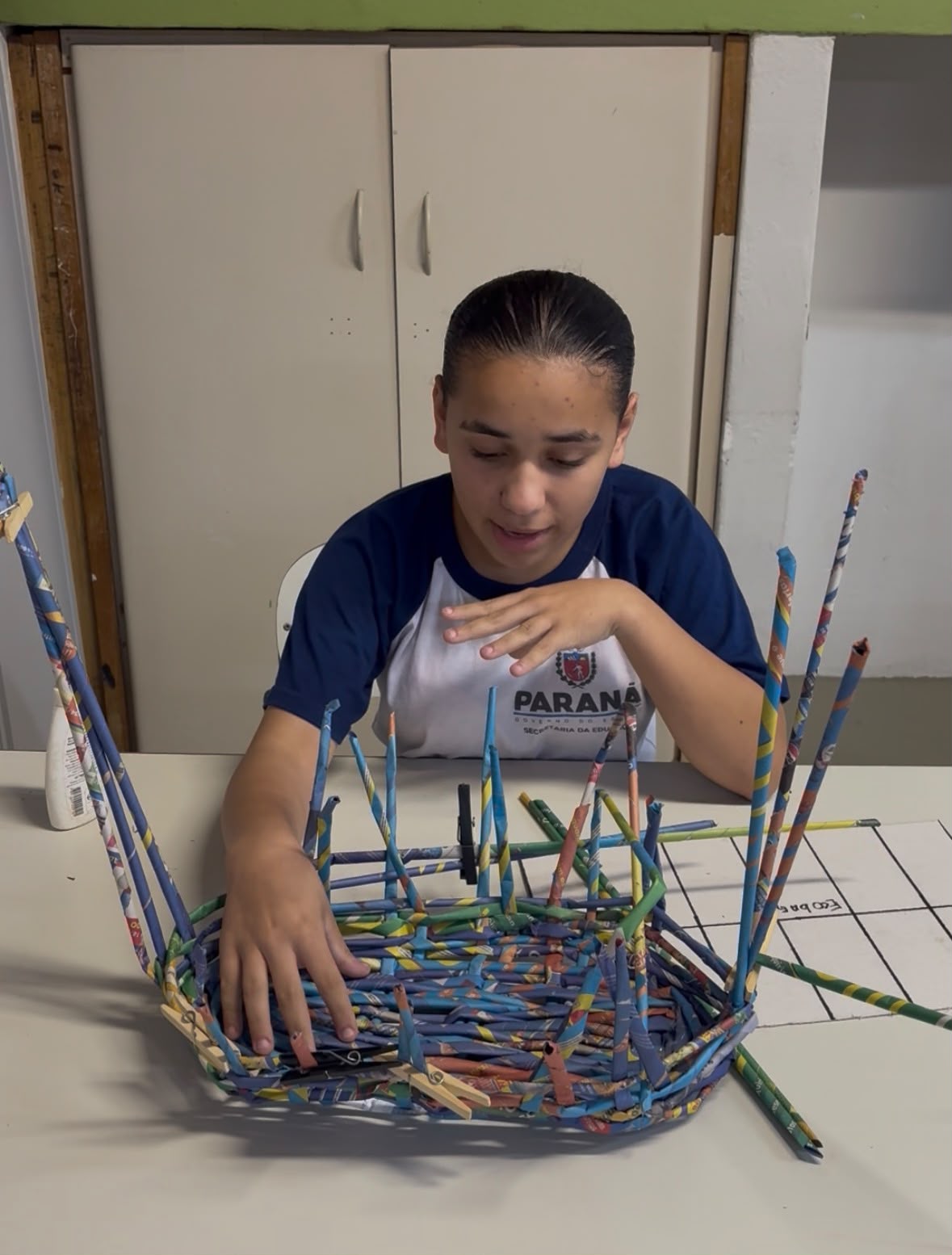 Aluna montando a estrutura trançada da ECOBAG
