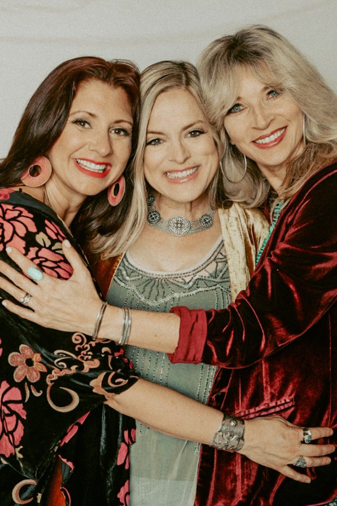 Sister Golden Hair band members embracing during a live performance in Austin, Texas