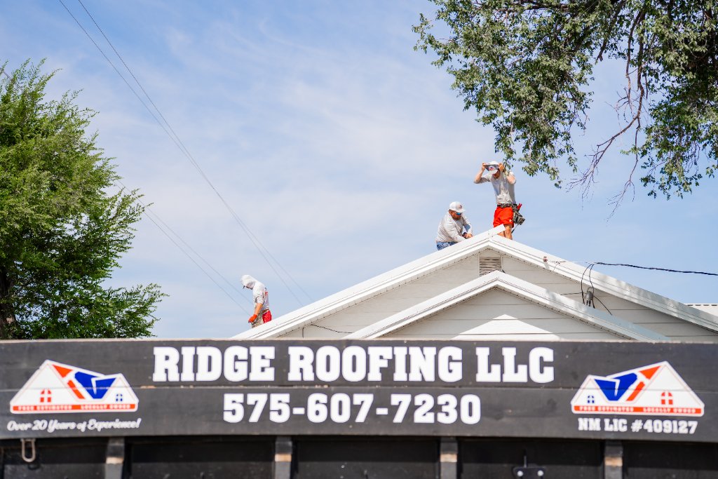Ridge Roofing LLC sign with crew on roof