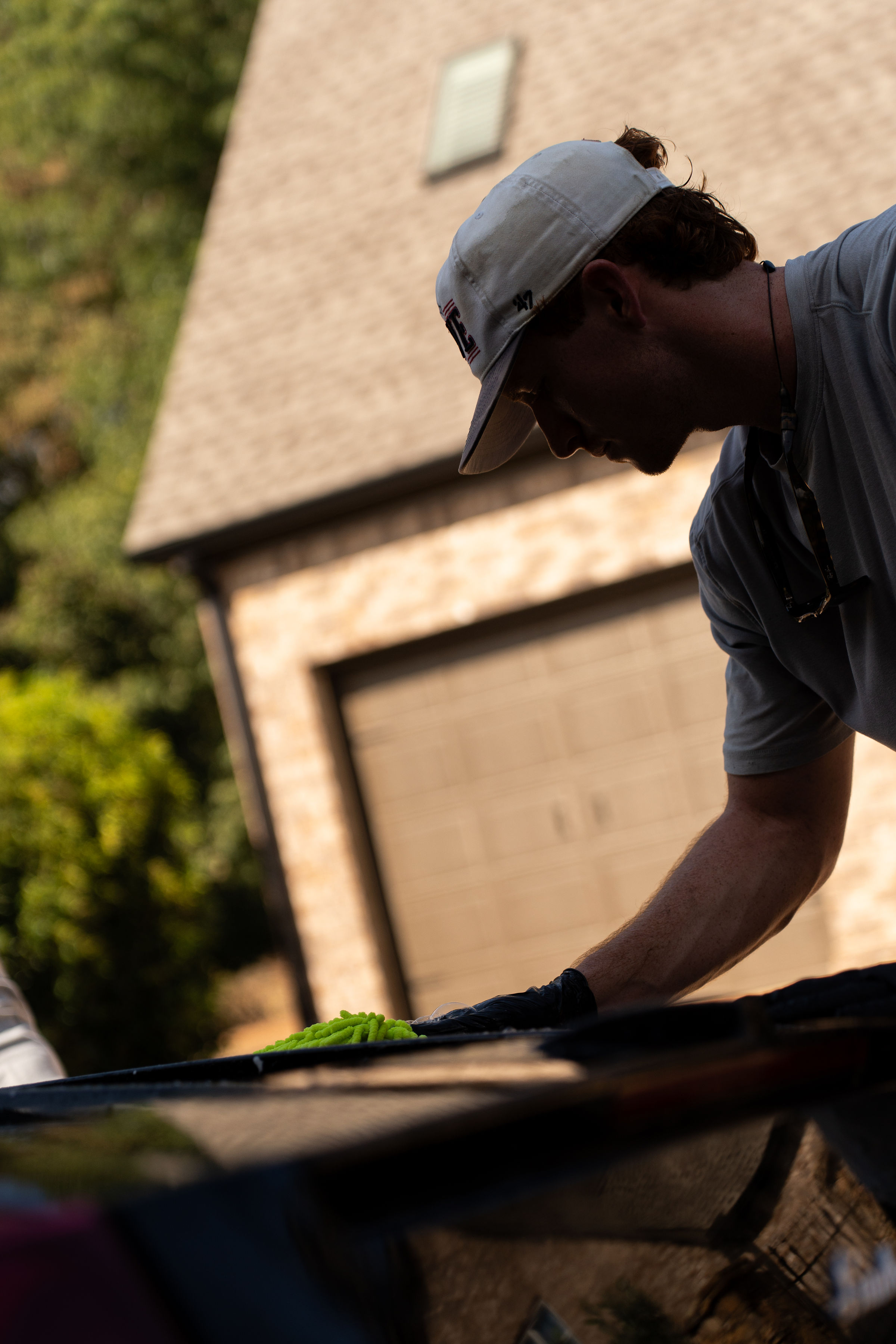 Detailer hand-washing a vehicle with a microfiber mitt