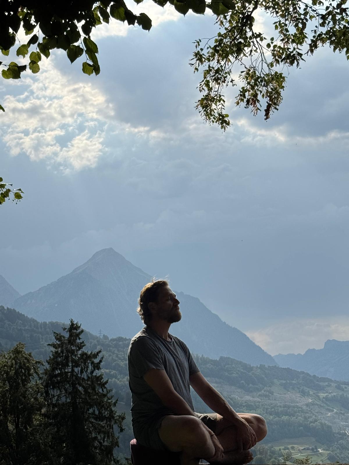 Andy Varonier meditiert vor Bergkulisse