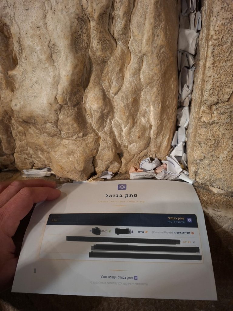 Your prayer note resting against the ancient stones — moments before placement.