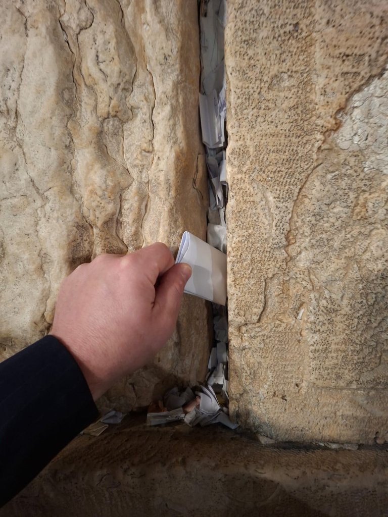 The moment your prayer reaches the Wall — placed by hand, with care and full intention.