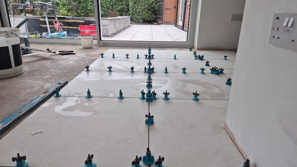 Precision tile layout with spacers and levelling system