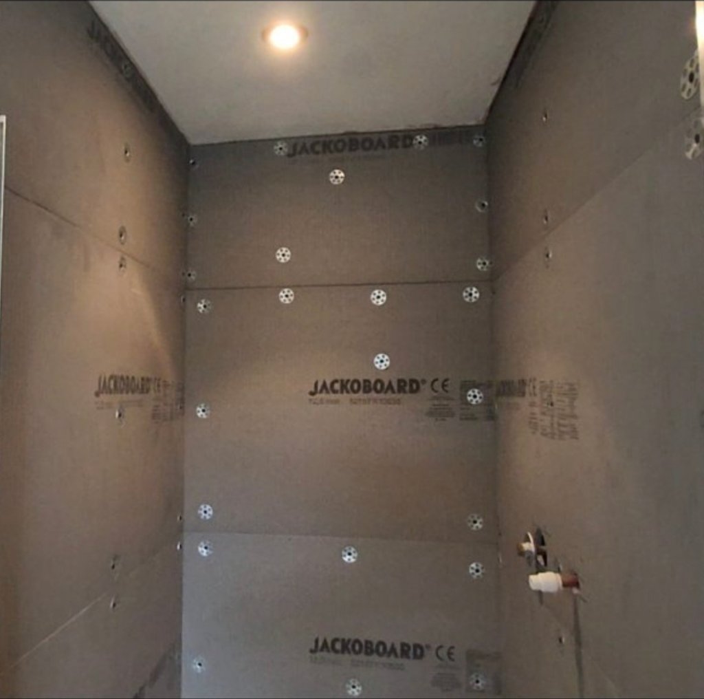 Jackoboard cement backer board installed across shower walls before tiling begins