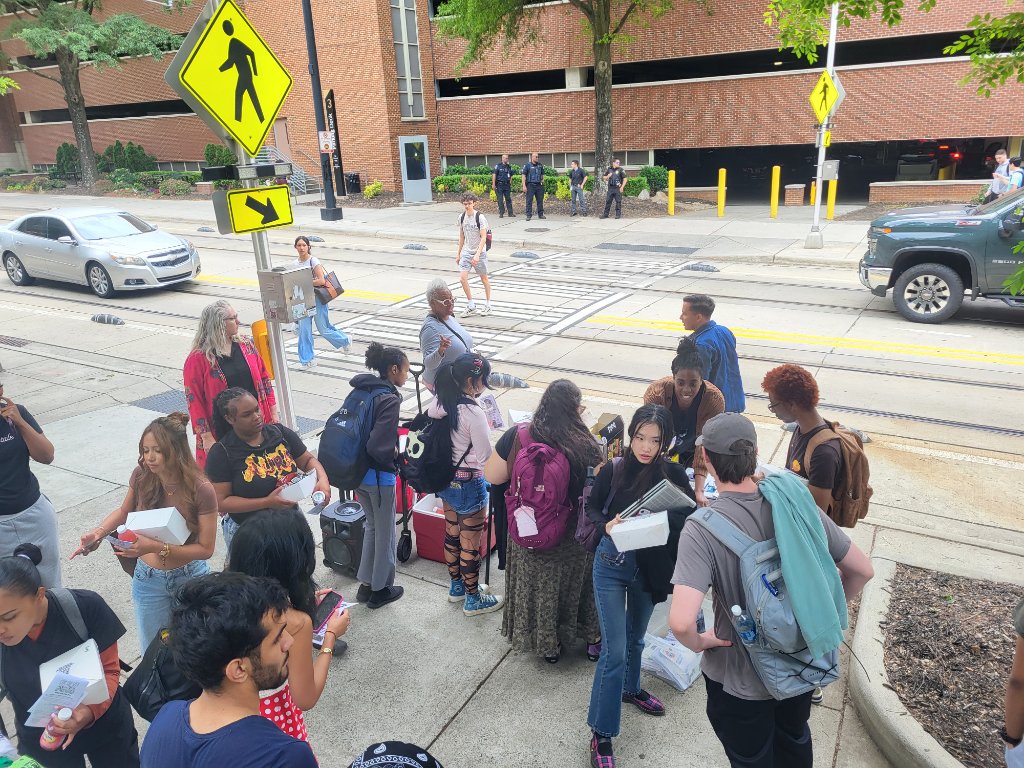 Students gathered on the sidewalk outside CPCC Central Campus during the walkout action