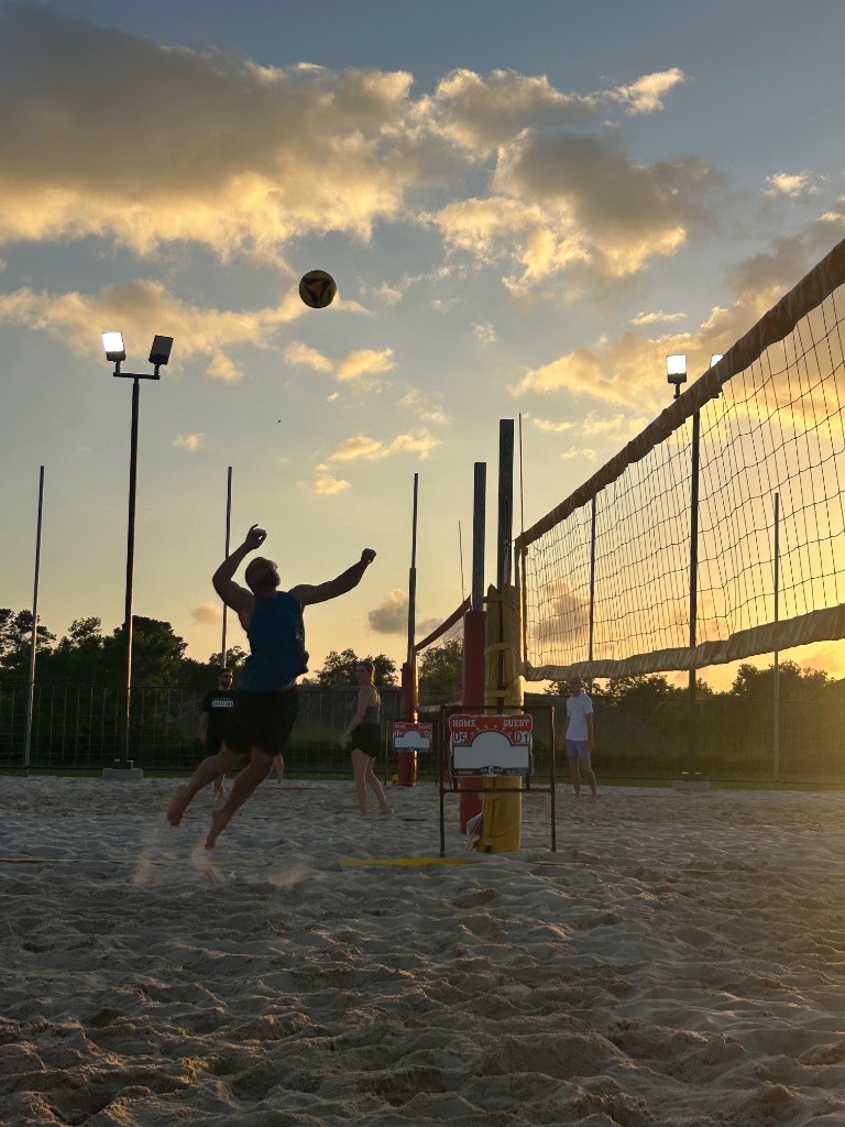 Player attacking near the net at sunset