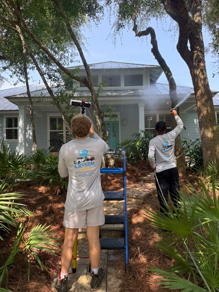 Crystal Glow crew pressure washing a home