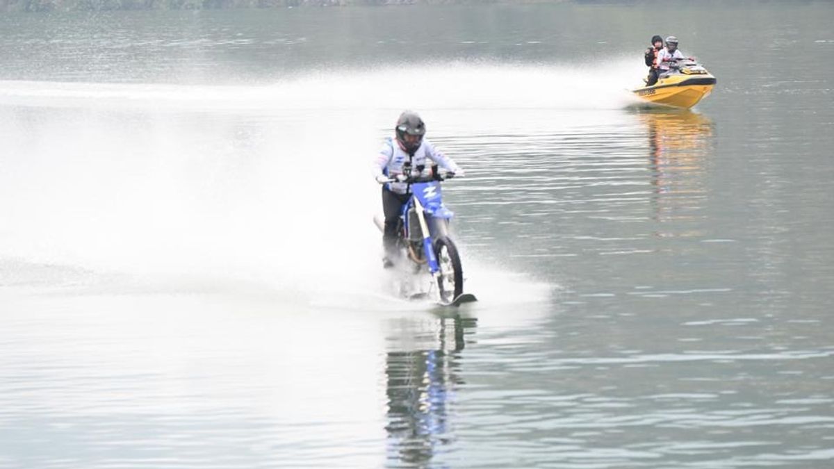 Penunggang menunggang motosikal ZXMOTO yang diubah suai khas merentasi permukaan air sungai dengan bot penyelamat di belakang